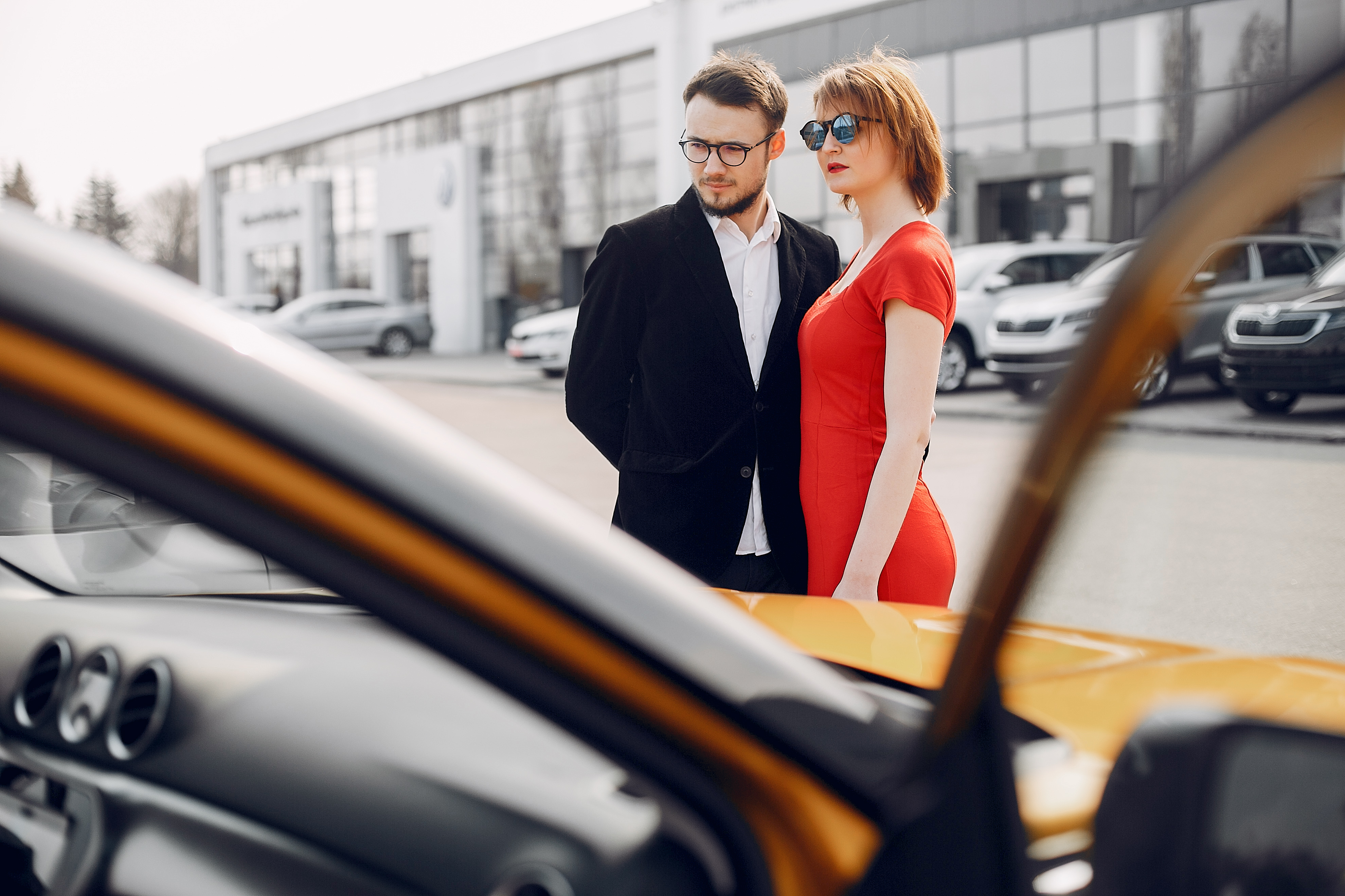 Couple in a car salon. Family buying the car. Elegant woman with her husband.